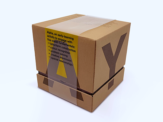 Child assembling Letterform: Alpha alphabet cards on a table.